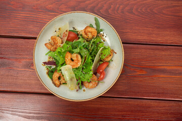 Mix of salad with shrimps , avocado and cherry tomatoes . Healthy food background