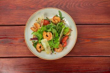 Mix of salad with shrimps , avocado and cherry tomatoes . Healthy food background