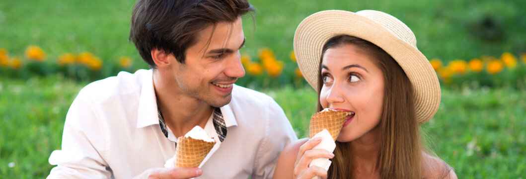 Young smiling couple eating ice cream in summer