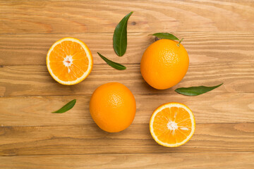 Flat lay with fresh oranges and leaves on wooden background