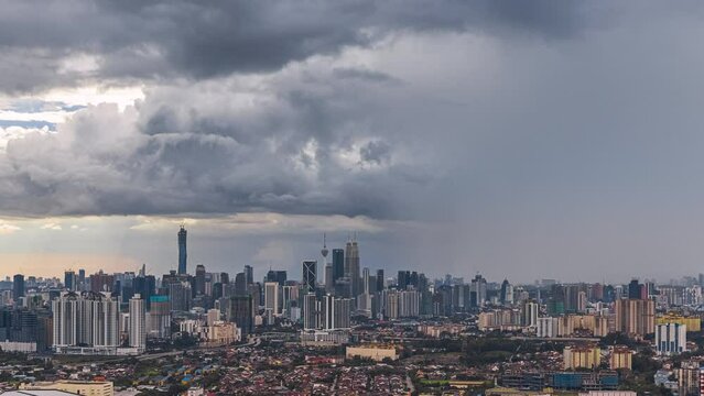 Monsoon cityscape time lapse with Dark clouds rain curtains and busy expressway against the Kuala Lumpur city skyline at sunset from afar in Malaysia. Zoom out motion timelapse. Prores 4KUHD.
