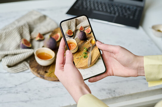 Close-up of young woman learning to take pictures of still life on her smartphone