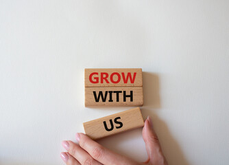 Grow with us symbol. Wooden blocks with words Grow with us. Beautiful white background. Businessman hand. Business and Grow with us concept. Copy space.