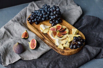 High angle view of ripe fruits and cheese on wooden tray lying perfectly for shooting of still life portrait