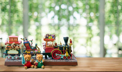 Christmas party decoration with bear and mini train toy on wood table