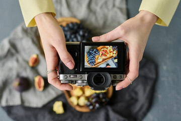 High anlge view of photographer making photo of fresh fruits on wooden board using her professional camera
