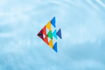 rainbow-colored suncatcher fish under water against the background of waves