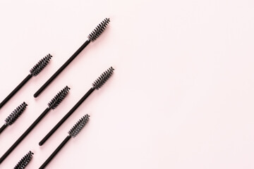 Set of brushes for eyelashes and eyebrows on pink background. Correction and care. Cooling and laying. Womens cosmetics.