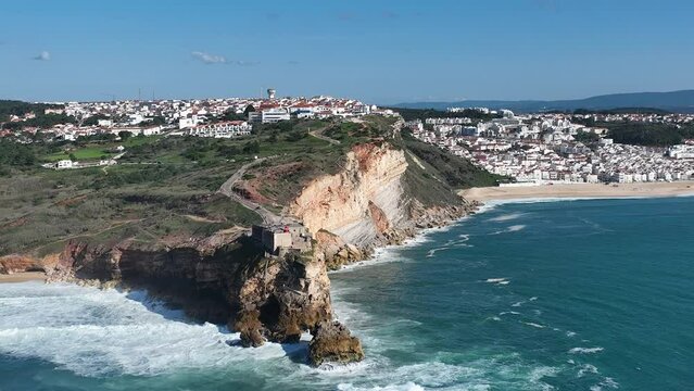Lighthouse in Nazare, Portugal. Famous place for waves and surfing. Beach and Ocean Waves in Background. 4k