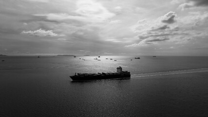 black and white cargo container ship sailing in sea to import export goods and distributing products to dealer and consumers across worldwide, by container ship Transpor