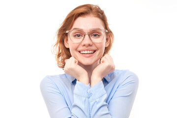 Fototapeta premium Portrait of attractive red-haired girl in business shirt and glasses smiling joyfully isolated on white studio background.