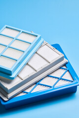 New clean dust air filters for vacuum cleaner isolated on blue background
