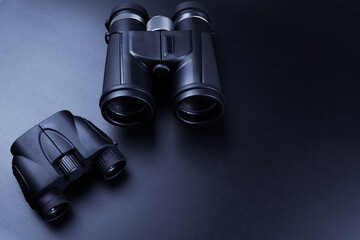 New binoculars isolated on black background. Flat lay, top view