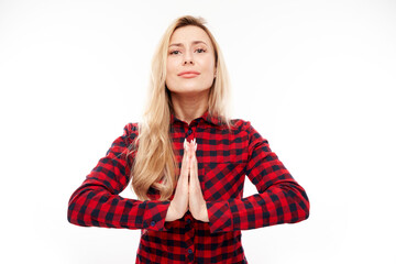 Portrait of young blonde woman folded her hands in prayer gesture isolated on white background. Peaceful, grateful, trusting, makes a wish concept