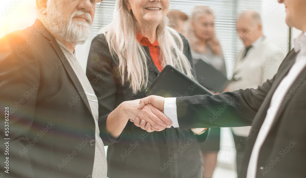 Canvas Prints close up. two businessmen shaking hands in the office lobby. handshake at sunset with a sun glare