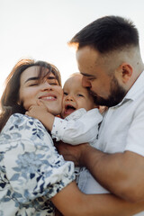 Happy young family spend time together outside in green nature