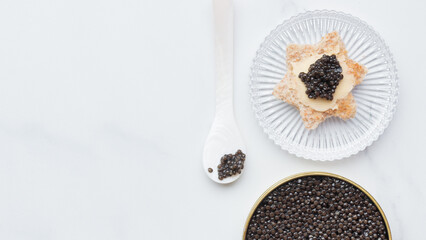 Black caviar appetizer in a mother-of-pearl spoon - obrazy, fototapety, plakaty