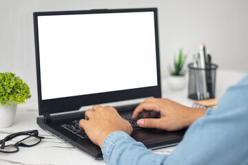 man's hands working on laptop in front of white