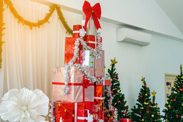 Colorful Christmas gift boxes with ribbon and Christmas decorations on table in house to celebrate New Year and Christmas season. Beautiful holiday decorated room with gift boxes and Christmas tree.