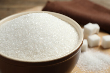 Fototapeta na wymiar Granulated sugar in bowl on table, closeup