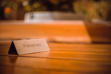 Sign Reserved on wooden table in restaurant. Space for text