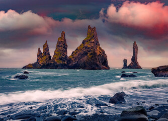 Majestic summer view of Reynisdrangar cliffs. Spectacular sunrise on Atlantic ocean. Gorgeous...