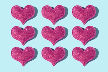 Pattern made from glitter heart shape on colored background with hard shadow. Valentines day minimalistic design