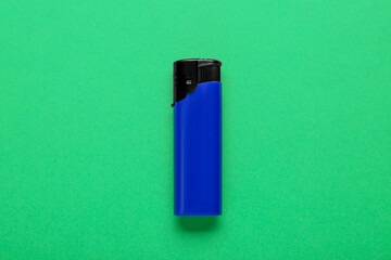 Stylish small pocket lighter on green background, top view