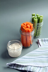Crudités: celery and carrot sticks served in small Mason jars with creamy ranch dip. Space for text.