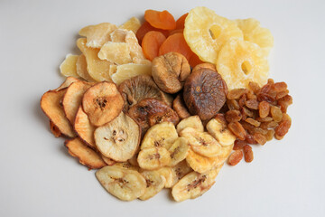 Pile of different dried fruits on white background, top view