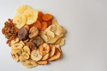 Pile of different dried fruits on white background, top view. Space for text