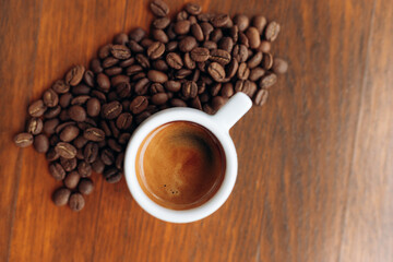 Coffee cup and coffee beans on wooden background. Top view
