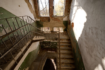 Stairs in an abandoned house, a destroyed industrial building, a house with broken windows.