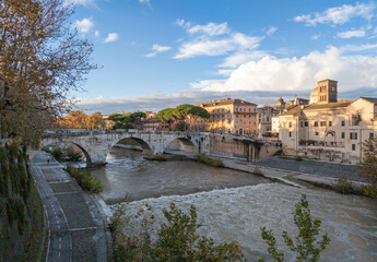 Fototapeta na wymiar Rome (Italy) - The Tiber river and the monumental Lungotevere street in the metropolitan capital of Italy. Here in particular the Isola Tiberina island.