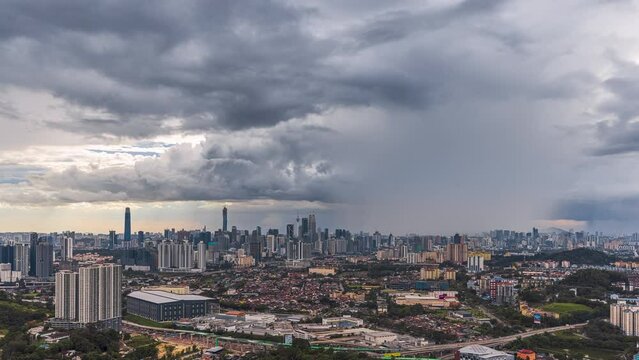 Monsoon cityscape time lapse with Dark clouds rain curtains and busy expressway against the Kuala Lumpur city skyline at sunset from afar in Malaysia. Prores 4KUHD Timelapse.
