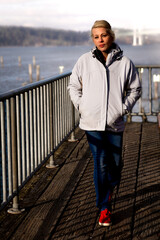 Attractive blonde woman walking along the waterfront.