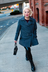 Fashionable blonde woman walking exploring the city.