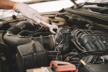 Automobile mechanic man checking car damage broken part condition, and repairing vehicle at home garage