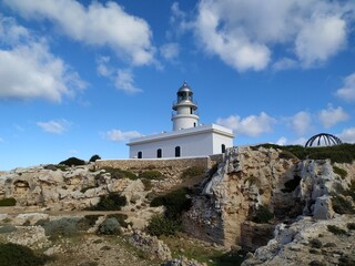Fototapeta na wymiar cape cavalleria lighthouse on the edge of a cliff protecting the ships of the Mediterranean sea