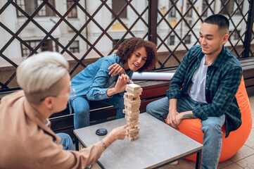 Three friends playing a board game on the veranda