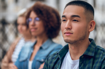 Obraz premium Cute pensive young man in the company of women