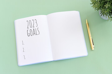 Business concept of top view 2023 goals list with notebook over wooden desk