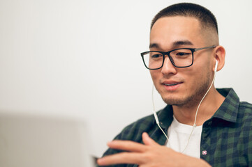 Freelancer communicating with someone via Skype using earphones