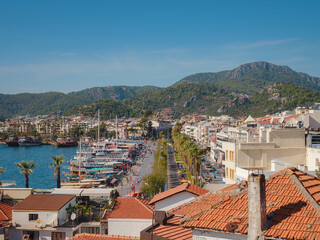 Naklejka na ściany i meble Marmaris is resort town on Turkish Riviera, also known as Turquoise Coast. Beautiful streets of old Marmaris. Narrow streets with stairs among houses with white bricks, green plants and flowers