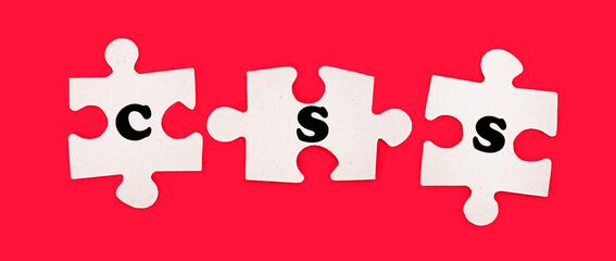 Three white jigsaw puzzles with the text CSS Cascading Style Sheets on a bright red background.