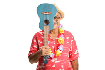 Smiling man hiding behind ukulele instrument