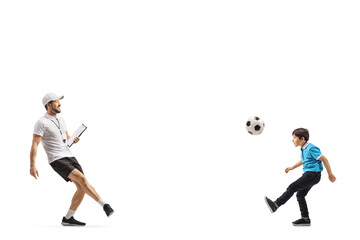 Fototapeta na wymiar Football coach kicking a ball with a boy