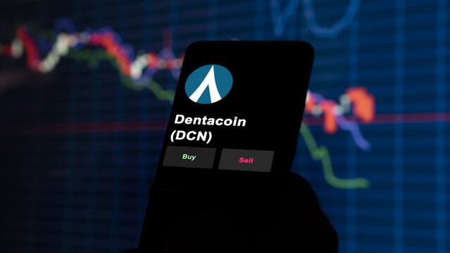November 3th 2022, Roma. An investor's analyzing the dentacoin (DCN) coin on screen. A phone shows the crypto's prices to invest