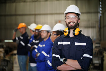 Young confident leader of team standing in front of factory workers