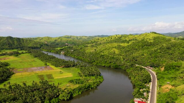 Tropical landscape in sunny weather. Village by the river. Green hills and river. Summer and travel vacation concept. The nature of the Philippine Islands, Samar